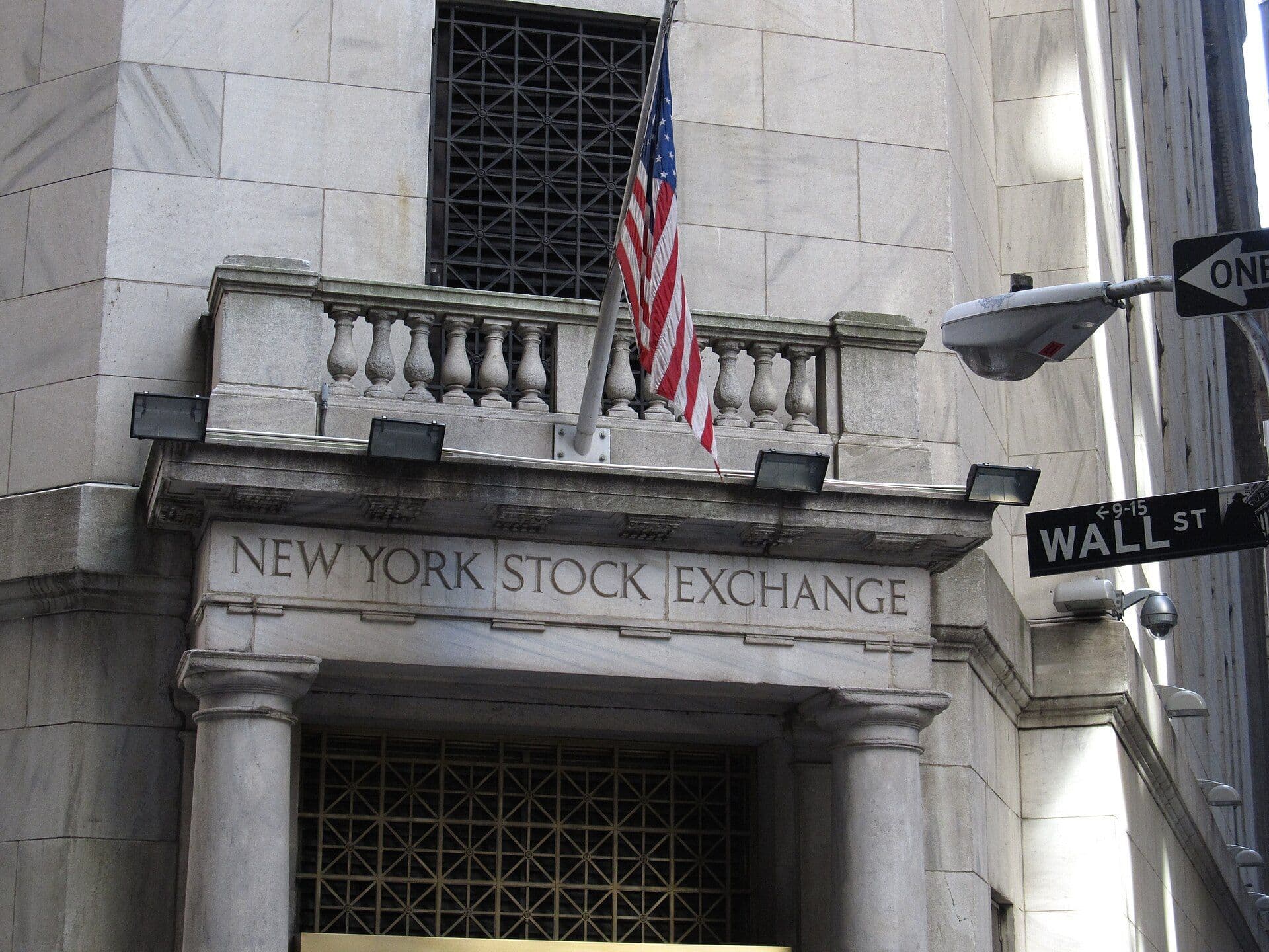 The New York Stock Exchange building with Wall Street sign and U.S. flag