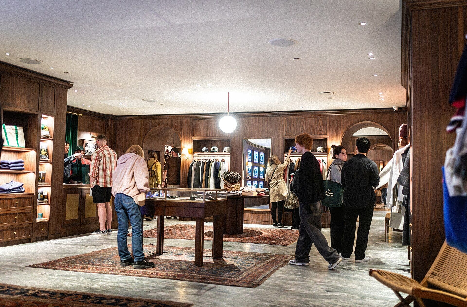 Interior of a modern retail store with dark wooden displays and clothing merchandise