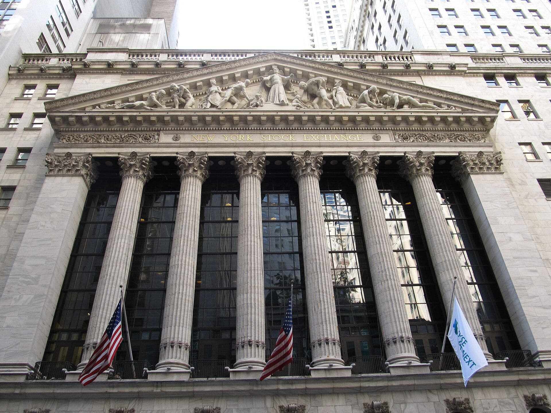 The New York Stock Exchange building facade with columns and American flags