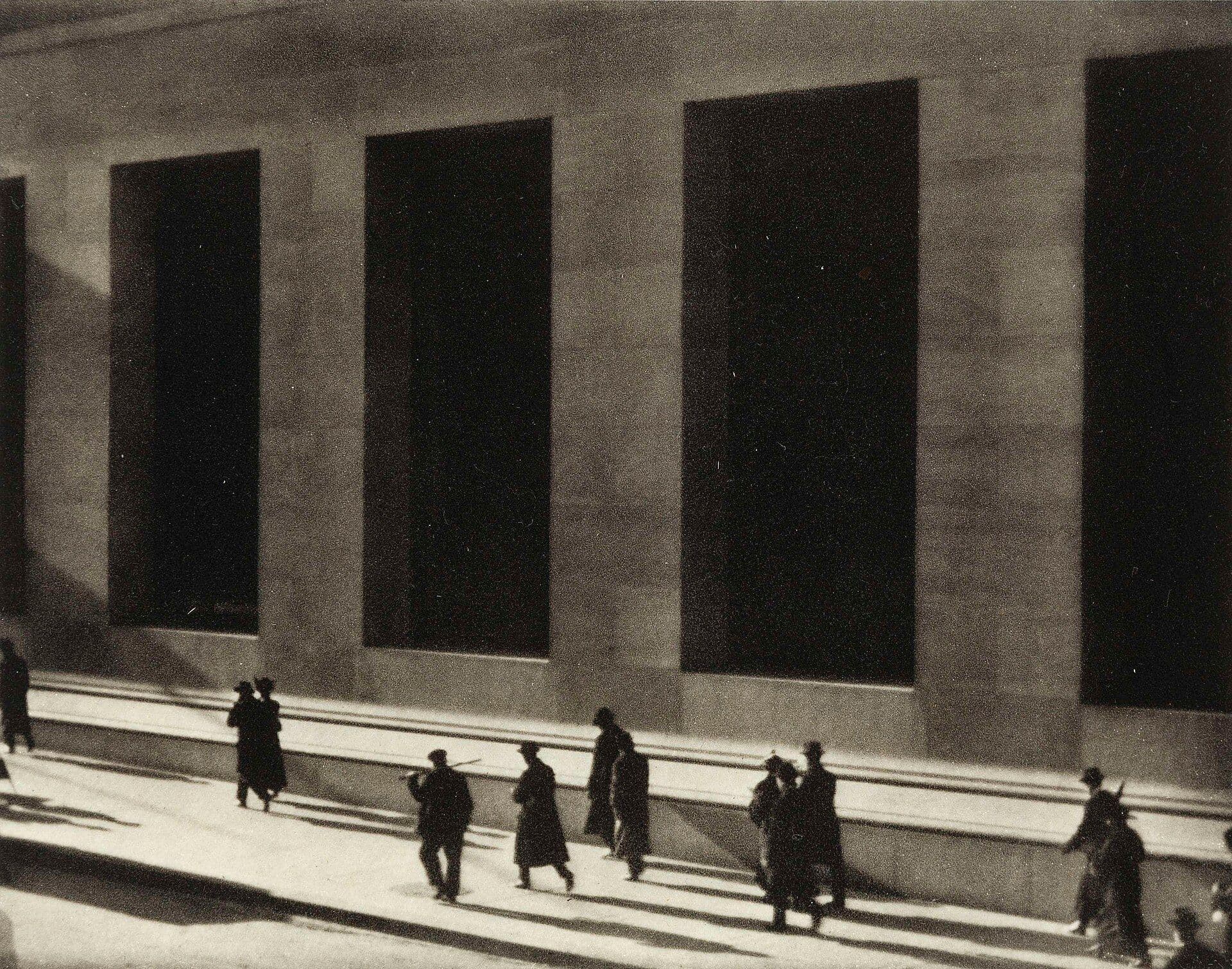 White marble building facade at Wall and Broad Streets with pedestrians