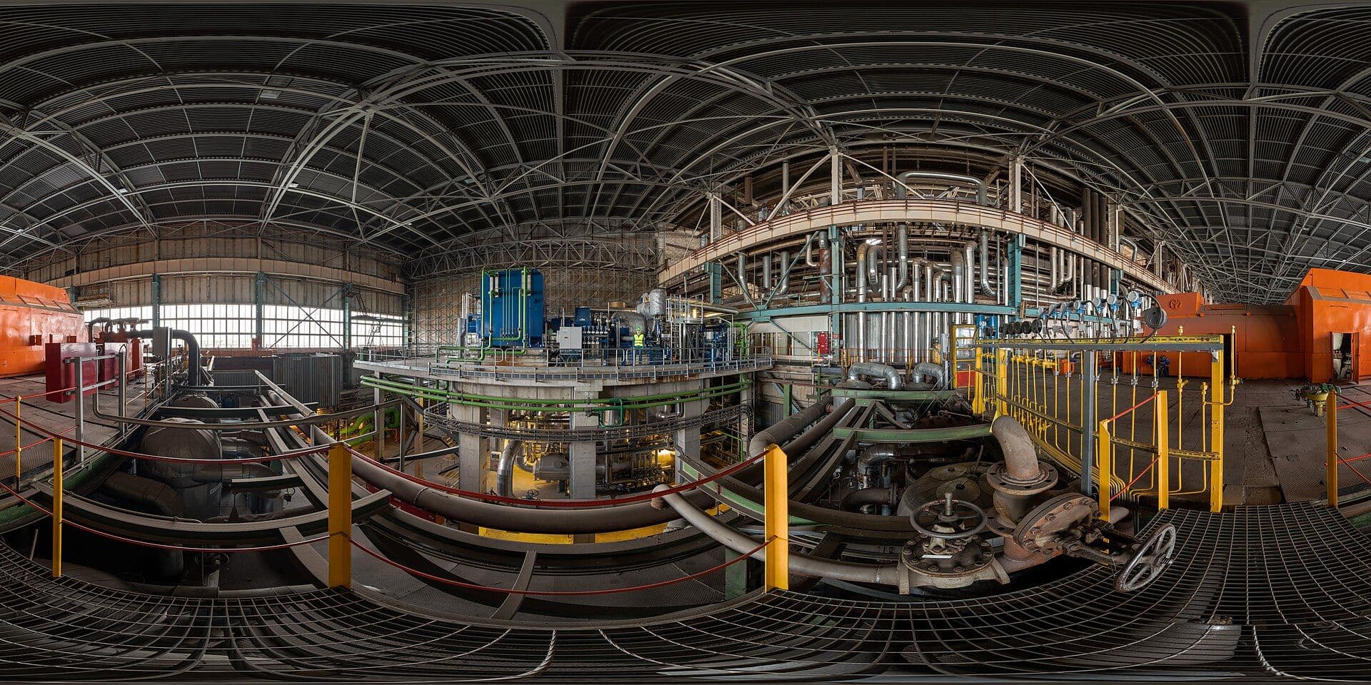 Industrial turbine hall with large generators and machinery inside a thermal power plant