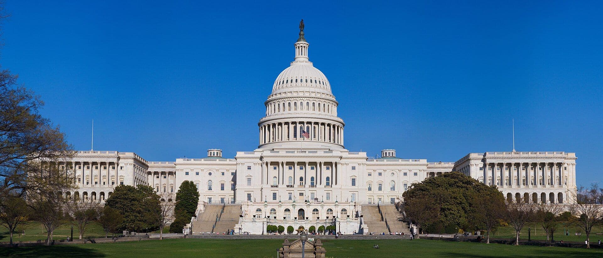 The U.S. Capitol building with its central dome, photographed during daytime with blue sky