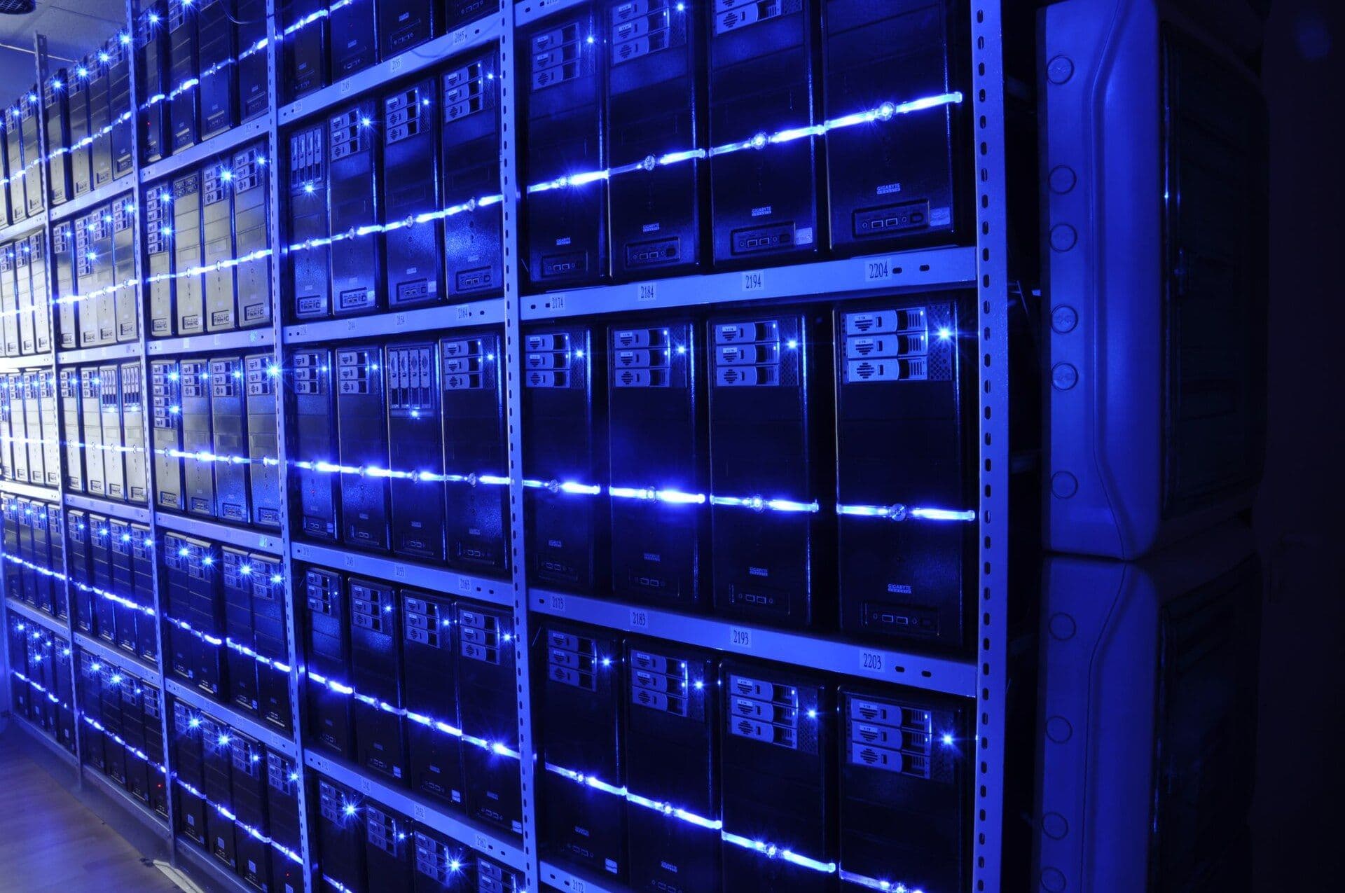 Interior of a data center server room with illuminated networking equipment mounted on metal racks